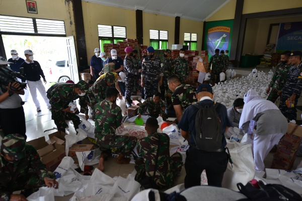 Suasana pengemasan paket bantuan beras dibantu oleh anggota TNI AD dan TNI AL yang berlangsung di ruang Aula Makodim 1205/STG.