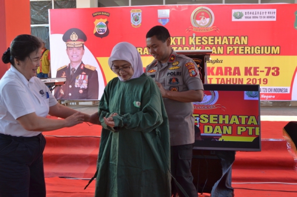 Kapolda Papua Barat, Brigjen Pol. Drs Herry Rudolf Nahak, M.Si memakaikan seragam operasi kepada salah satu dokter sebagai penanda dimulainya Baksos Kesehatan Tzu Chi ke-173 di RS Bhayangkara Lodewijk Mandatjan, Manokwari, Papua Barat.