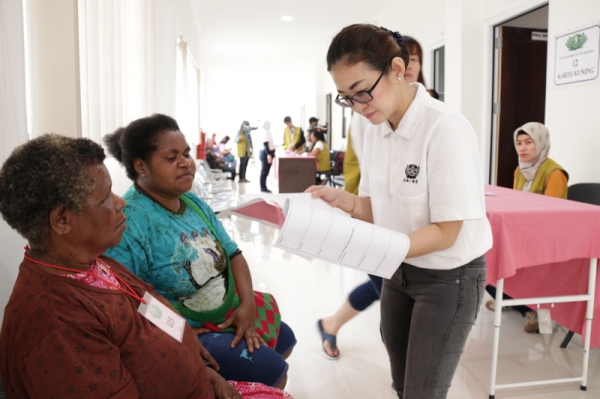 Drg. Yuni Yanan, relawan medis asal Manokwari tengah memeriksa berkas calon pasien baksos kesehatan.
