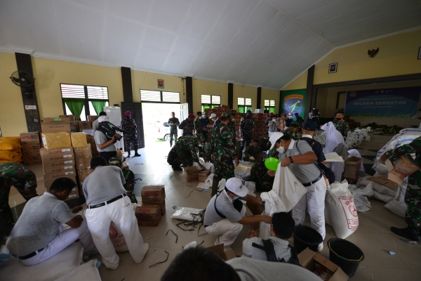 Relawan Tzu Chi bersama prajurit TNI Kodim 1205/STG dan prajurit TNi AL besama-sama mengemas paket bantuan yang berisi beras 10 kg, minyak goreng, mi instan dan biskuit di ruang serbaguna Makodim 1205/STG.