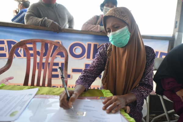 Salah satu dari delapan calon warga Perumahan Cinta Kasih Tzu Chi Pombewe sedang menandatangani surat perjanjian hunian tetap. Setelah itu mereka bisa mendapatkan kunci rumah dan bisa menempatinya.