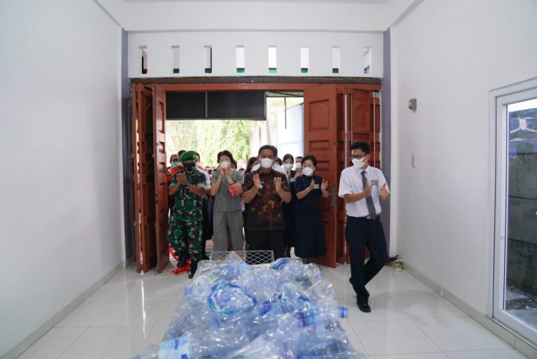 Relawan Tzu Chi Hasan Tina menemani para tamu undangan secara resmi memasuki depo baru ini.