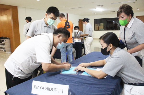 Relawan dengan sigap mendampingi Herman Yuyu (kiri) untuk mengambil bantuan rutin biaya hidup yang diterimanya dari Tzu Chi.